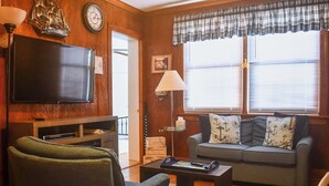 A living room with a flat-screen TV, a sofa, a coffee table, and a lamp. - 8 Mi to Broadway: Wfh-friendly Nashville Duplex! (Nashville)