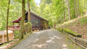 Eine Holzhütte mit einer Terrasse, umgeben von einem Wald.