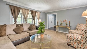 A living room with a beige sofa, a glass coffee table, patterned armchairs, and a potted plant. - Charming Marietta Home ~ 7 Mi to Downtown! (Marietta)