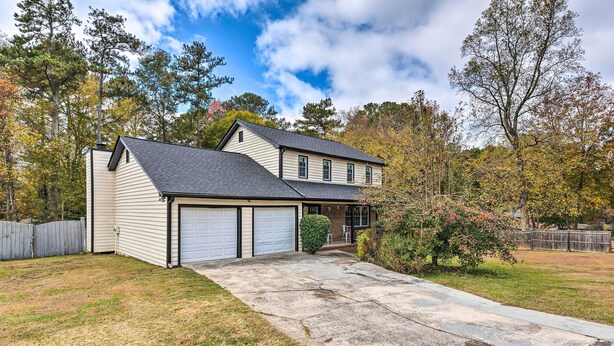 A two-story house with a garage, a covered front porch, and a well-maintained lawn. - Charming Marietta Home ~ 7 Mi to Downtown! (Marietta)