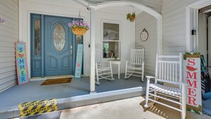 A porch with white rocking chairs, a blue door, and a welcome sign. - Waterfront Sparta Home w/ Game Room & Fire Pit! (Eatonton)