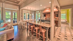 A spacious kitchen with a large island, bar stools, and a view of the outdoors. - Upscale Family Home w/ Dock on Lake Hartwell! (Hartwell)