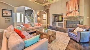 A spacious living room with a fireplace, a staircase, and a cozy seating area. - Upscale Family Home w/ Dock on Lake Hartwell! (Hartwell)
