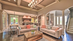 A spacious living room with a large sofa set, a coffee table, and a dining area with a table and chairs. - Upscale Family Home w/ Dock on Lake Hartwell! (Hartwell)