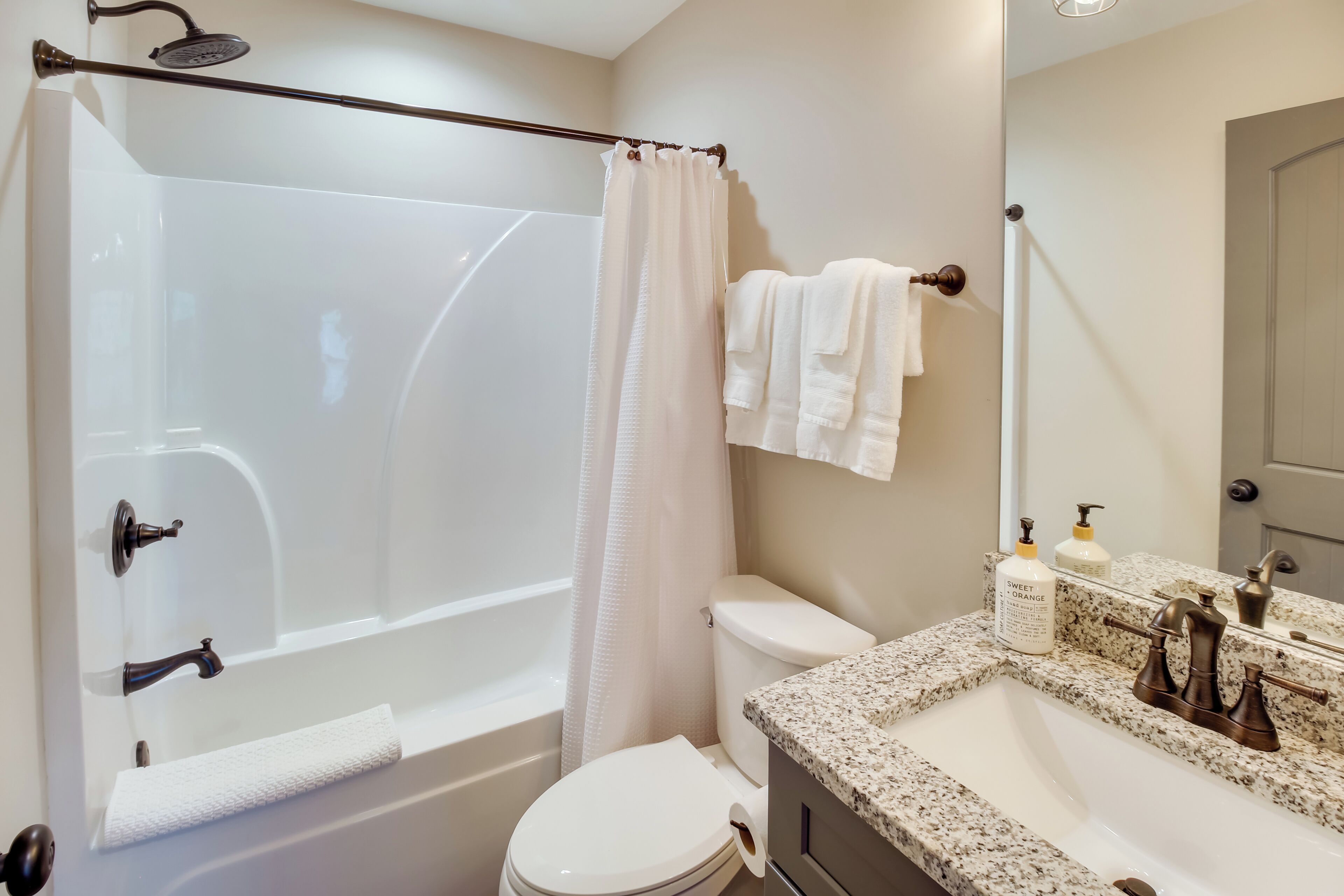 A bathroom with a bathtub, toilet, and sink.