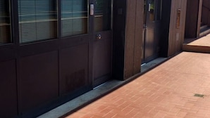 A building entrance with a dark wooden door and a tiled walkway. - Gemme Fiorentine Martina apartment free parking 5 minutes from centre by train  (Firenze)