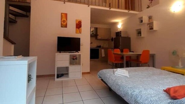 A compact room with a bed, a TV, a desk, and a dining area. - Gemme Fiorentine Martina apartment free parking 5 minutes from centre by train  (Firenze)