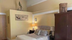 A bedroom with a bed, a nightstand, a lamp, a wardrobe, and two wall-mounted artworks. -  Historic Waterfront District., for lovers of art, restaurants, unique shops, 

 (Warren)