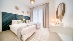 Een moderne hotelkamer met een groot bed, een bureau en een kaptafel met spiegel.