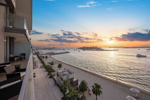 A beachfront hotel with a balcony overlooking the sea, a sandy beach, and a view of boats in the distance. - YOUR STAY Apartments Luxury Beachfront Living  (Dubai)