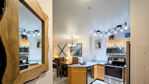 A modern kitchen with wooden cabinets, stainless steel appliances, and a central island. - River Run Summer Fun | Patio, Pool  & Hot Tub (Keystone)