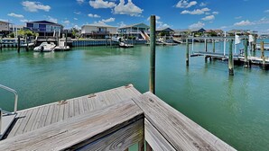 A marina with docked boats, wooden walkways, and buildings in the background.