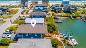 A coastal residential area with houses, a dock, and a marina.