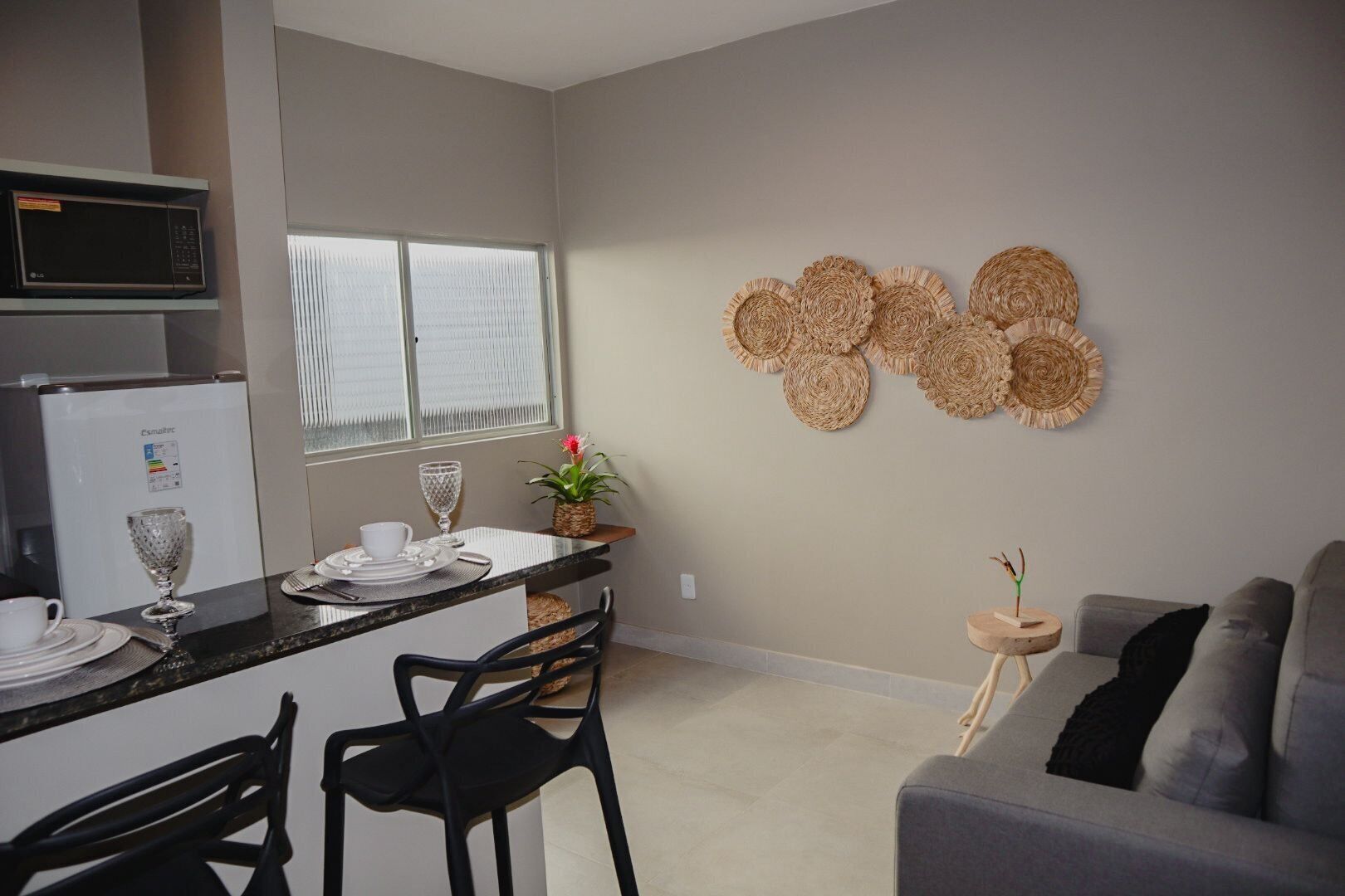 A compact kitchen with a refrigerator, microwave, and dining area with chairs and a table.