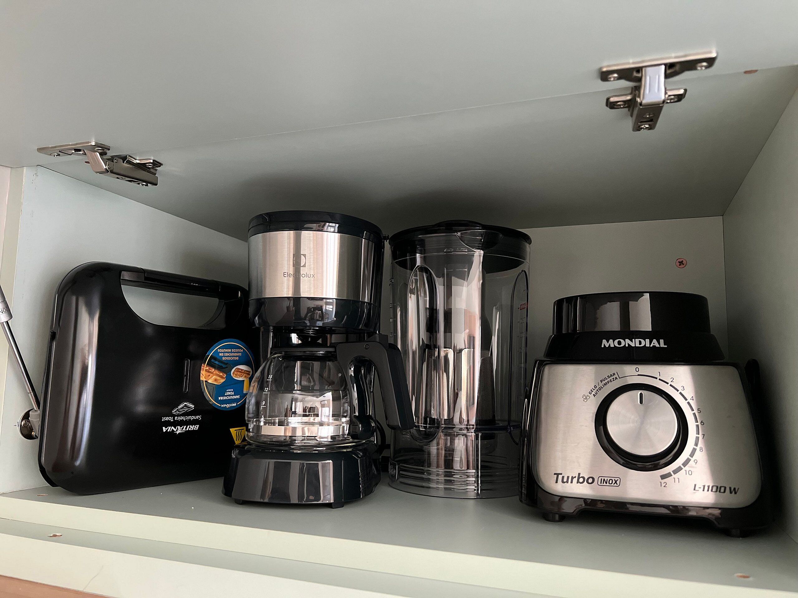 Uma cozinha equipada com cafeteira, liquidificador e processador de alimentos.
