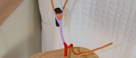 A wooden table with a figure of a person in a purple top and red skirt, standing on a square platform.