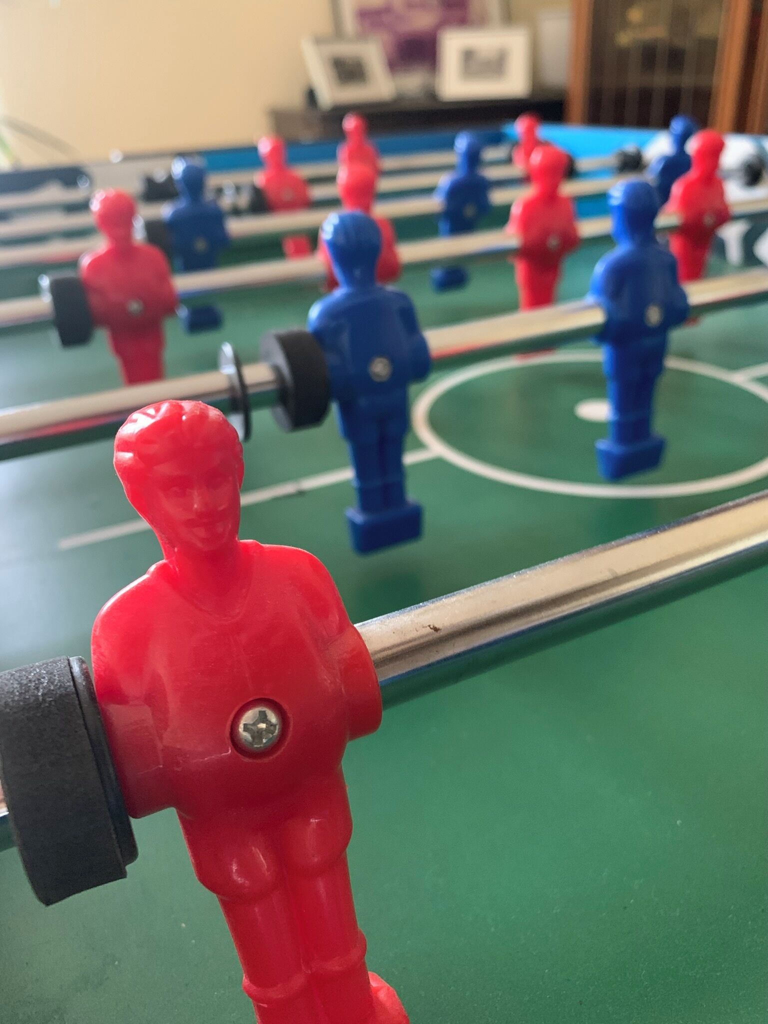 Primer plano de una mesa de fútbol de mesa con figuras rojas y azules.