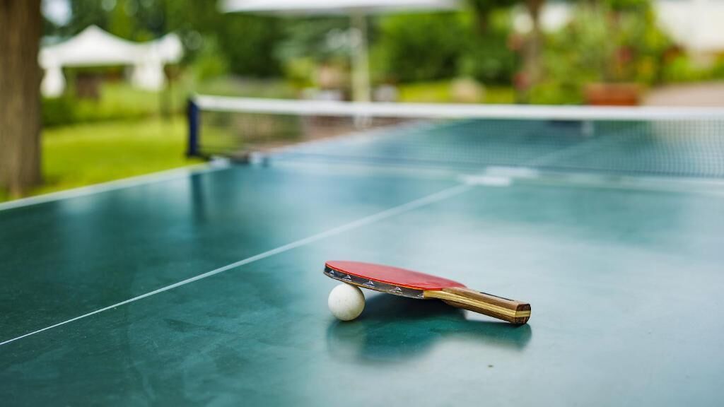 Ein Tischtennis-Tisch mit Schläger und Ball.