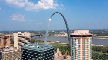 A cityscape with a prominent arch bridge, modern buildings, and a river.