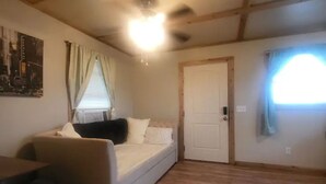 A room with a bed, a small table, and a window with curtains.