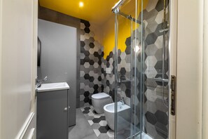 A modern bathroom with a glass shower enclosure, a toilet, and a bidet. - Loft Porta Maggiore - Three Bedroom Apartment, Sleeps 6 (Rome)
