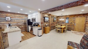 A log cabin interior with a kitchen, dining area, and a fireplace. - Rustic Retreat - Mt Crested Butte (Crested Butte)
