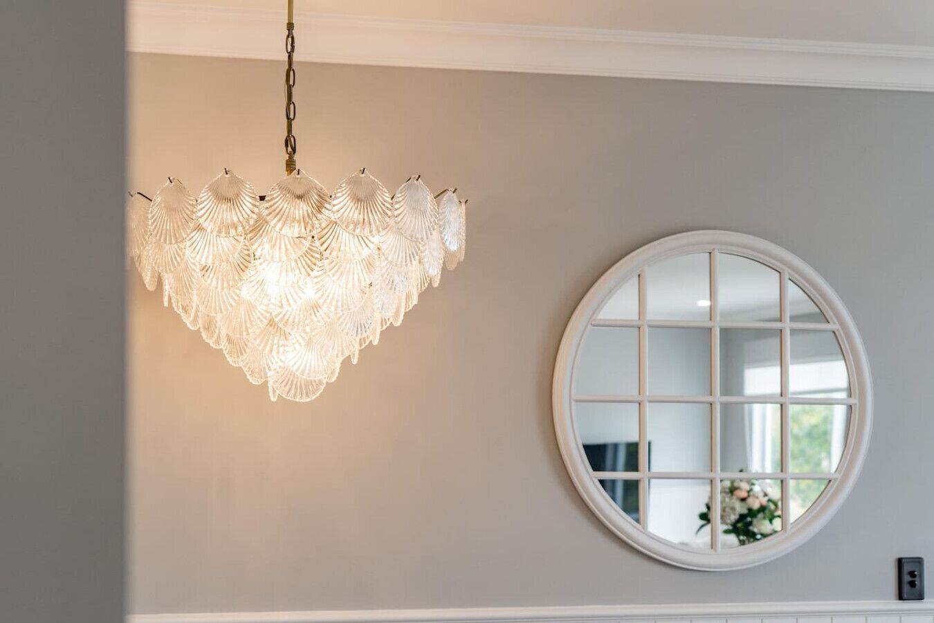 Un lustre à motifs festonnés est suspendu au plafond.