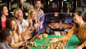 A group of people playing blackjack at a casino table with chips and cards. - Cute & Cozy Providence Studio! (Providence)