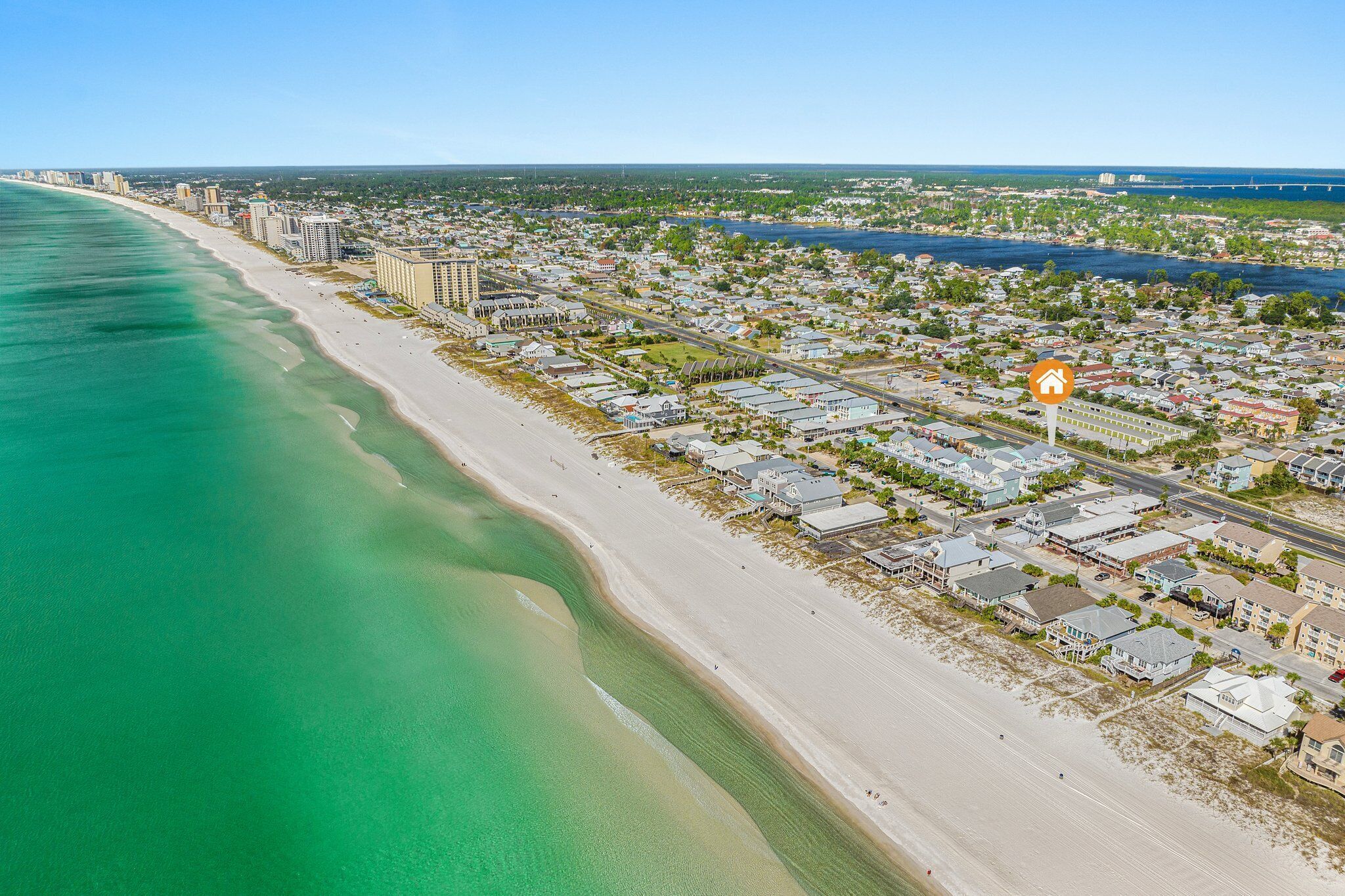 Vue aérienne d’une ville côtière avec une plage, des immeubles d’habitation et une rivière.