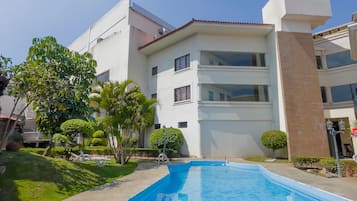 Una piscina al aire libre, sombrillas, tumbonas