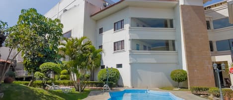 Una piscina al aire libre, sombrillas, tumbonas