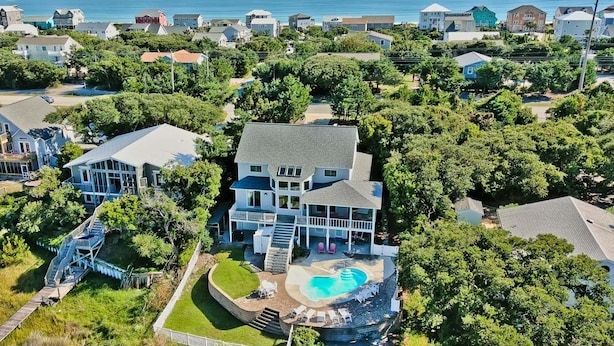 A large house with a swimming pool, surrounded by trees and other houses. - Witt's Inn, Soundfront House in Emerald Isle, NC! (Emerald Isle)