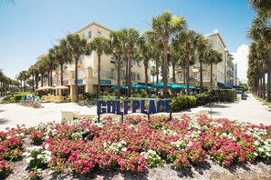 A hotel named "GULF PLACE" with a sign in the foreground, surrounded by palm trees and flower beds. - 30A Gulf Place Studio! 3 Pools, Pickleball & Prvt Beach, Fall Specials! (Santa Rosa Beach)