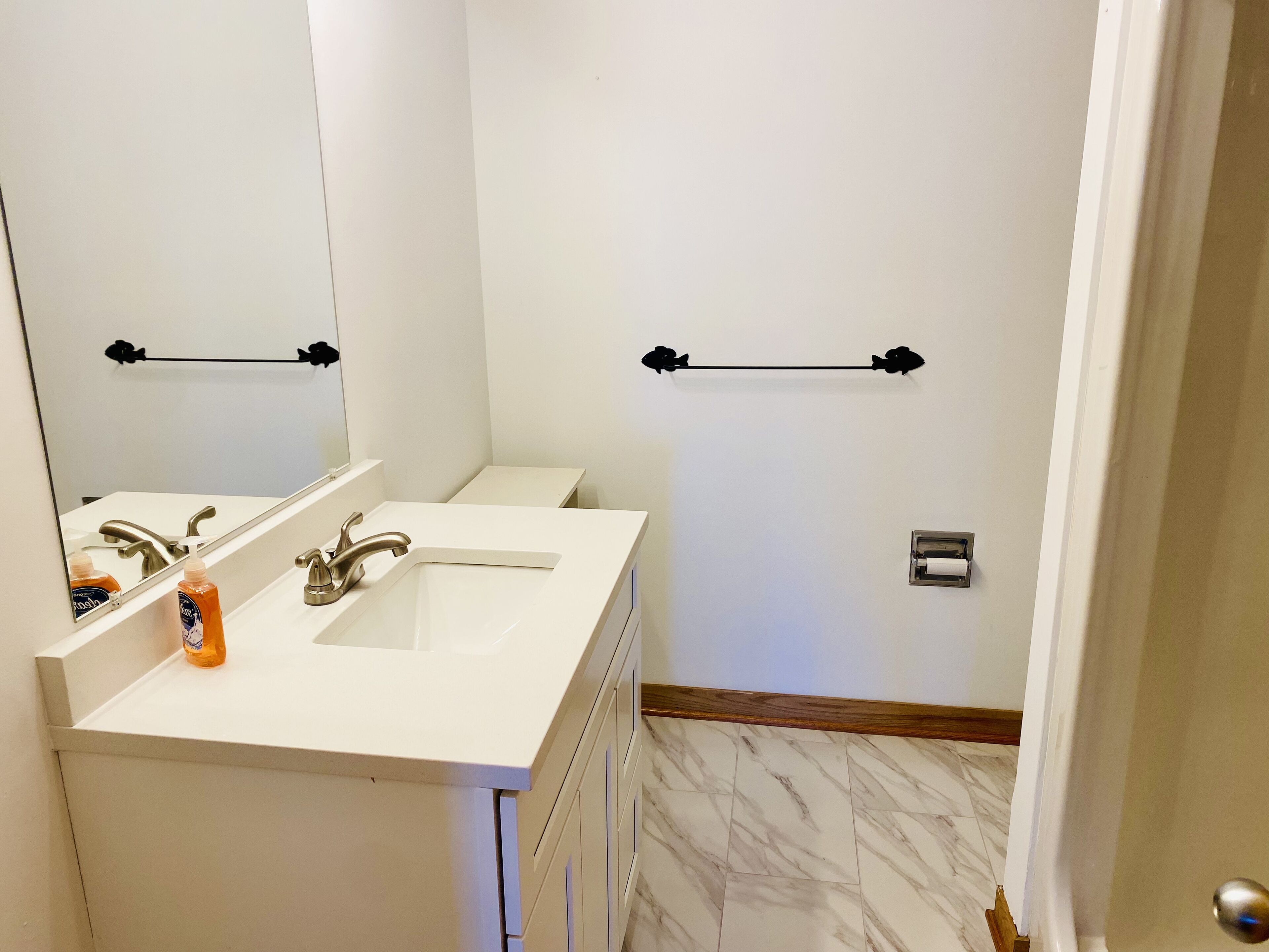 A bathroom with a white sink, a mirror, and a towel rack.