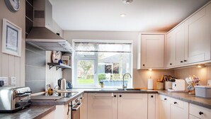 A modern kitchen with a built-in oven, a sink, and a window with a view of the outdoors.