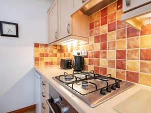 A kitchen with a gas stove, a toaster, and a coffee maker. - 2 bedroom accommodation in Inverness (Inverness)