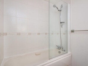 A bathroom with a glass-enclosed shower, a bathtub, and white tiled walls. - 2 bedroom accommodation in Inverness (Inverness)