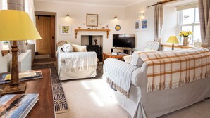 A cozy living room with a fireplace, a television, and a comfortable seating area. - White House - UKC6895 (Golspie)