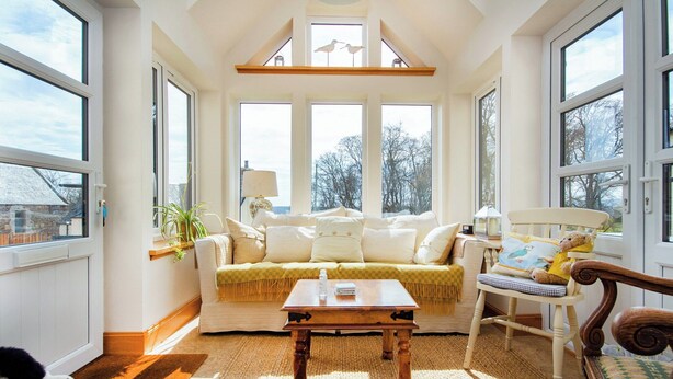 A cozy living room with a sofa, a wooden coffee table, a chair with a cushion, and a rug. - White House - UKC6895 (Golspie)