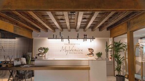 A reception desk with a sign reading "PALAZZETTO MyVenice BOUTIQUE HOTEL". - Palazzetto My Venice (Venice)