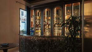 A bar area with a marble counter, shelves of bottles, and a decorative ceiling. - Palazzetto My Venice (Venice)