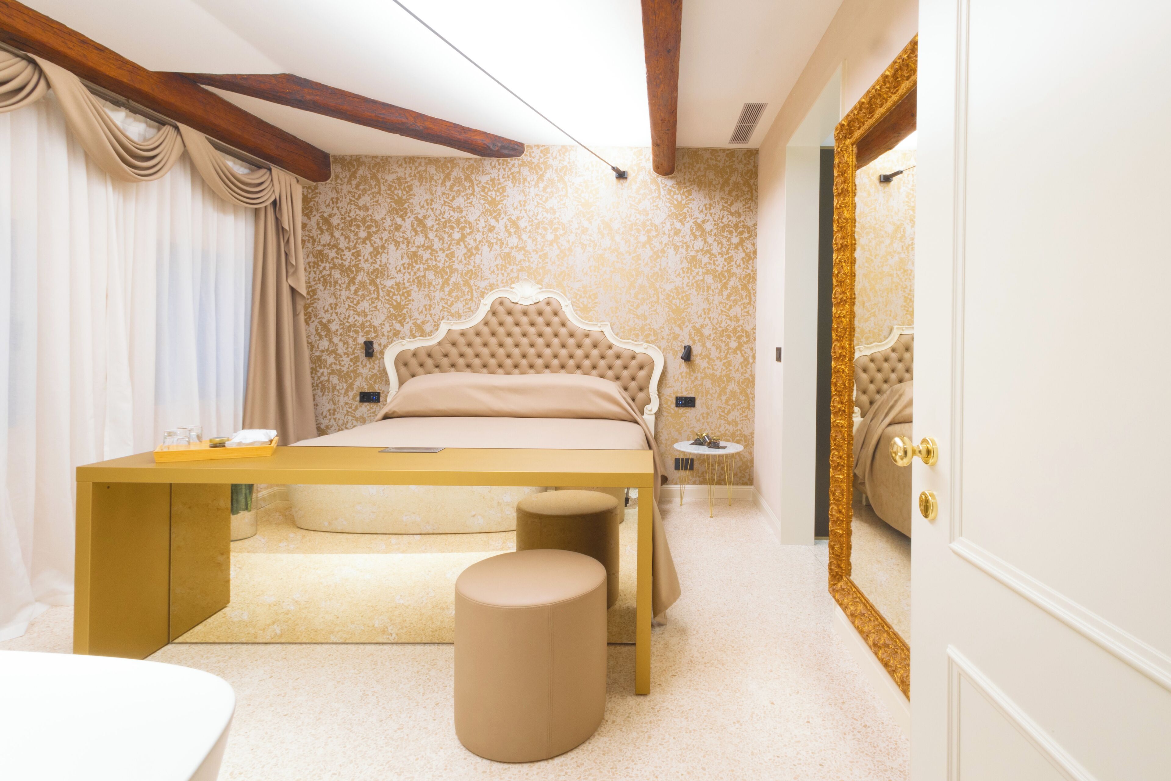 A bedroom with a bed, bedside tables, a mirror, and a wardrobe.