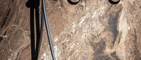 Une douche avec un mur en marbre en arrière-plan.
