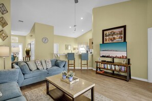 Relax in a spacious living area with a comfortable sofa, coffee table, and bookshelf, perfect for unwinding and entertaining.
