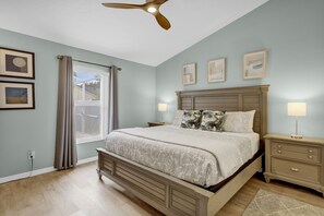 Cozy retreat with a large bed, nightstand, and window with curtains.