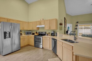 Prepare meals in the fully equipped kitchen with a refrigerator, oven, and dishwasher, plus a large island with a sink and microwave.