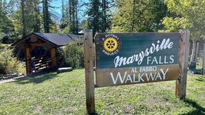Un letrero de madera indica el camino a las cascadas de Marysville y el sendero Al Fbro, con el logotipo de un proyecto Rotary.