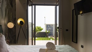 Una habitación de hotel con una cama, vistas al exterior y un televisor montado en la pared.