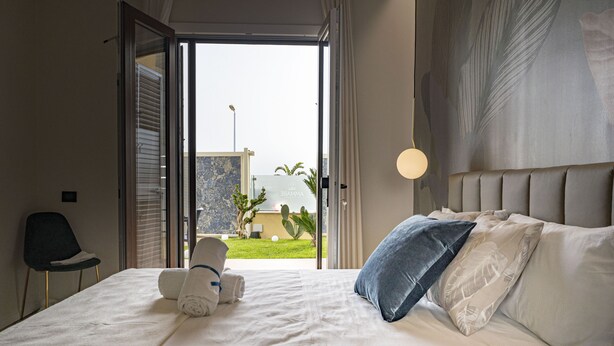Una habitación de hotel con una cama, una silla y vistas al exterior.