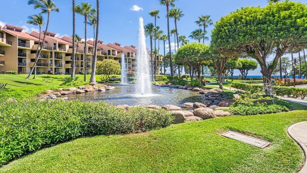 A hotel with a central water feature, surrounded by well-maintained lawns and palm trees. - 3-Min Walk to Beach! Ground Floor - No Resort Fee (Kihei)